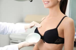 Doctor showing silicone implant for breast augmentation to patient