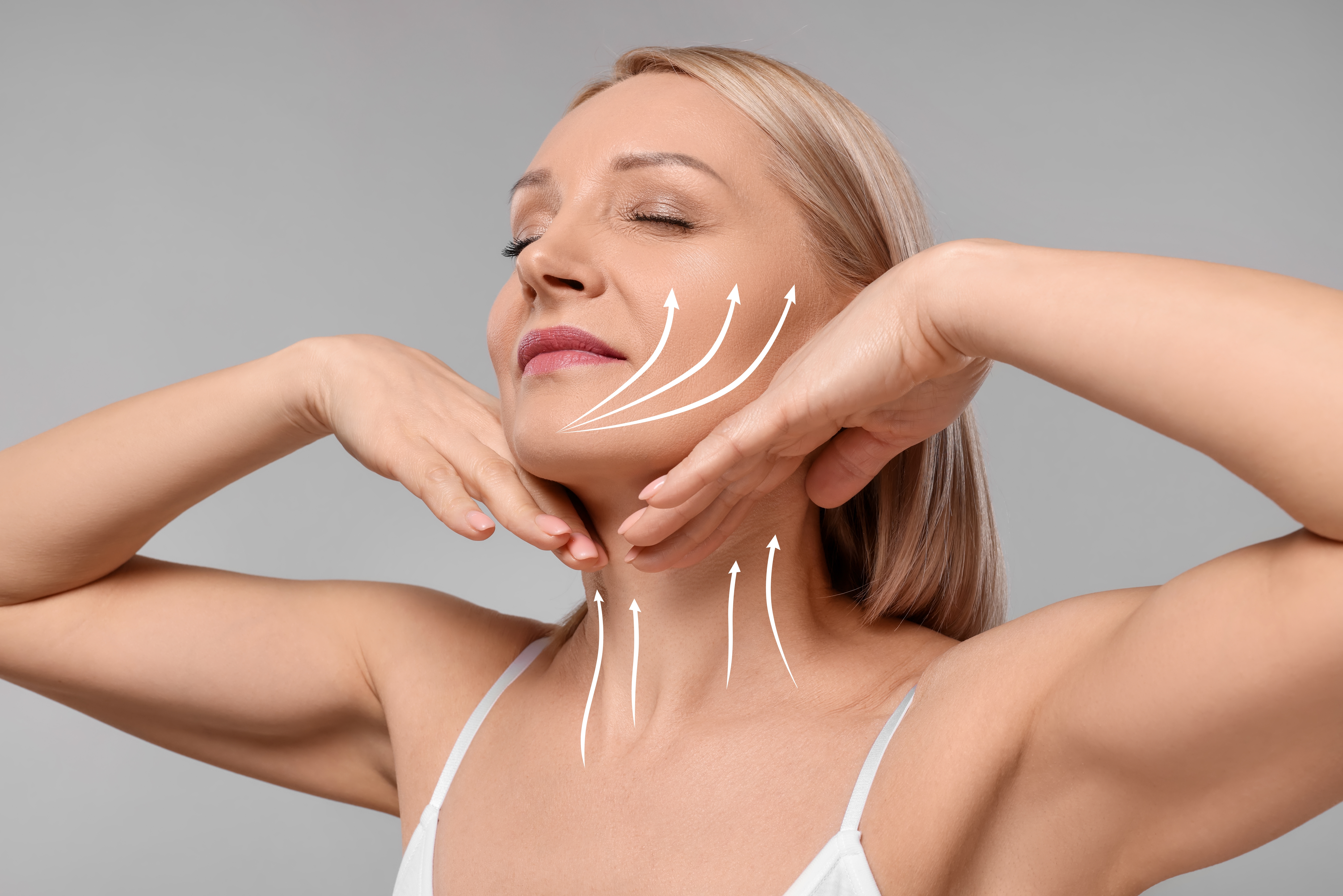 Woman holding her face in her hands and showing off her jawline after a facelift