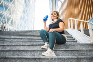 Woman taking a break from exercising, smiling due to weight loss injection results