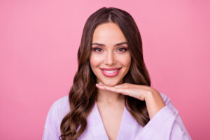 Woman smiling with hand under chin from chin implant in La Jolla, CA