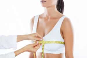 Woman having her breasts measured by surgeon for breast reduction in Carlsbad, CA
