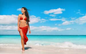 Slim woman in bikini on the beach after CoolSculpting treatment in La Jolla, CA
