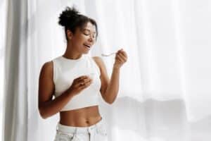 Woman smiling and eating showing her slim, toned figure from BodyTite in La Jolla, CA