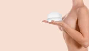 Side profile of woman's breasts as she olds breast implants in La Jolla, CA