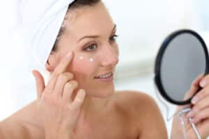 Woman applying moisturizer after her Morpheus8 treatment in La Jolla, CA