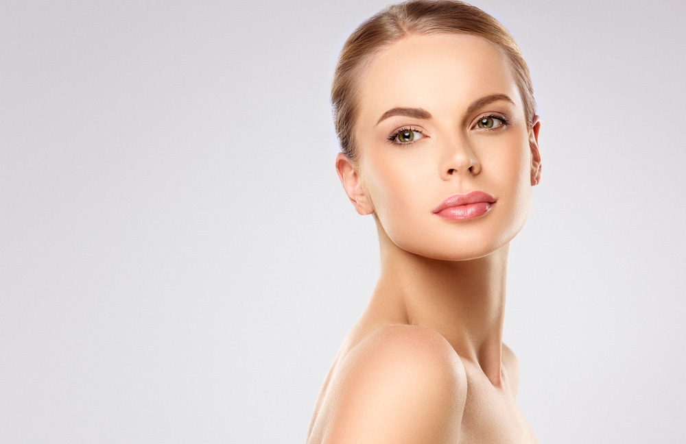 Side profile of woman's breasts as she olds breast implants in La Jolla, CA Woman with nice skin after IPL in La Jolla, CA