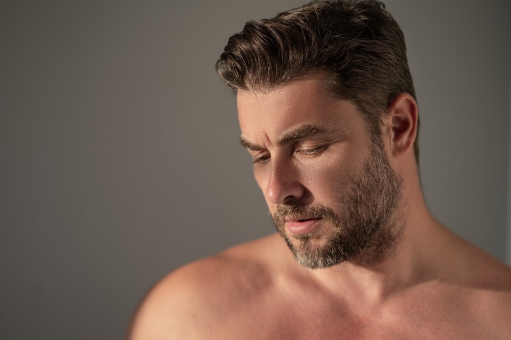 Side profile of woman's breasts as she olds breast implants in La Jolla, CA Man with full head of hair from NeoGraft Hair Restoration in La Jolla, CA